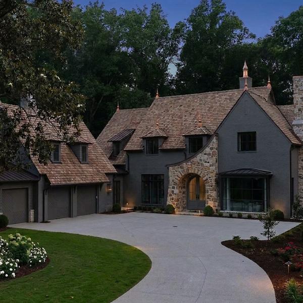 Dark grey Tudor Revival historic home in Morningside Atlanta featuring deep wooded lot and original underground plumbing infrastructure.